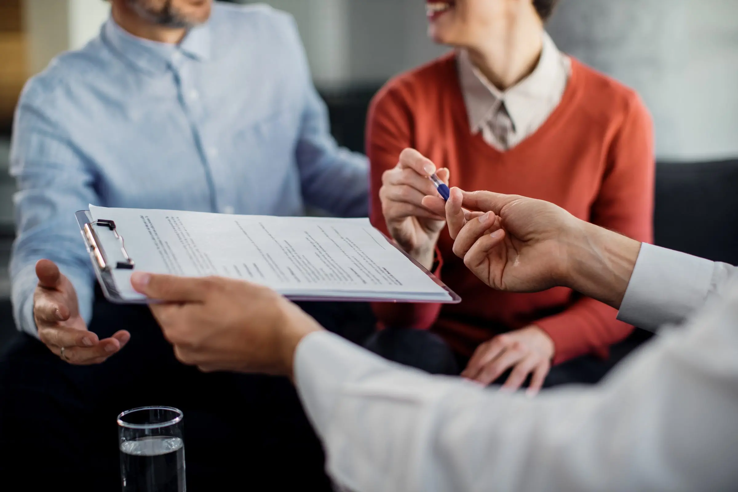 closeup unrecognizable couple signing contract with financial advisor1